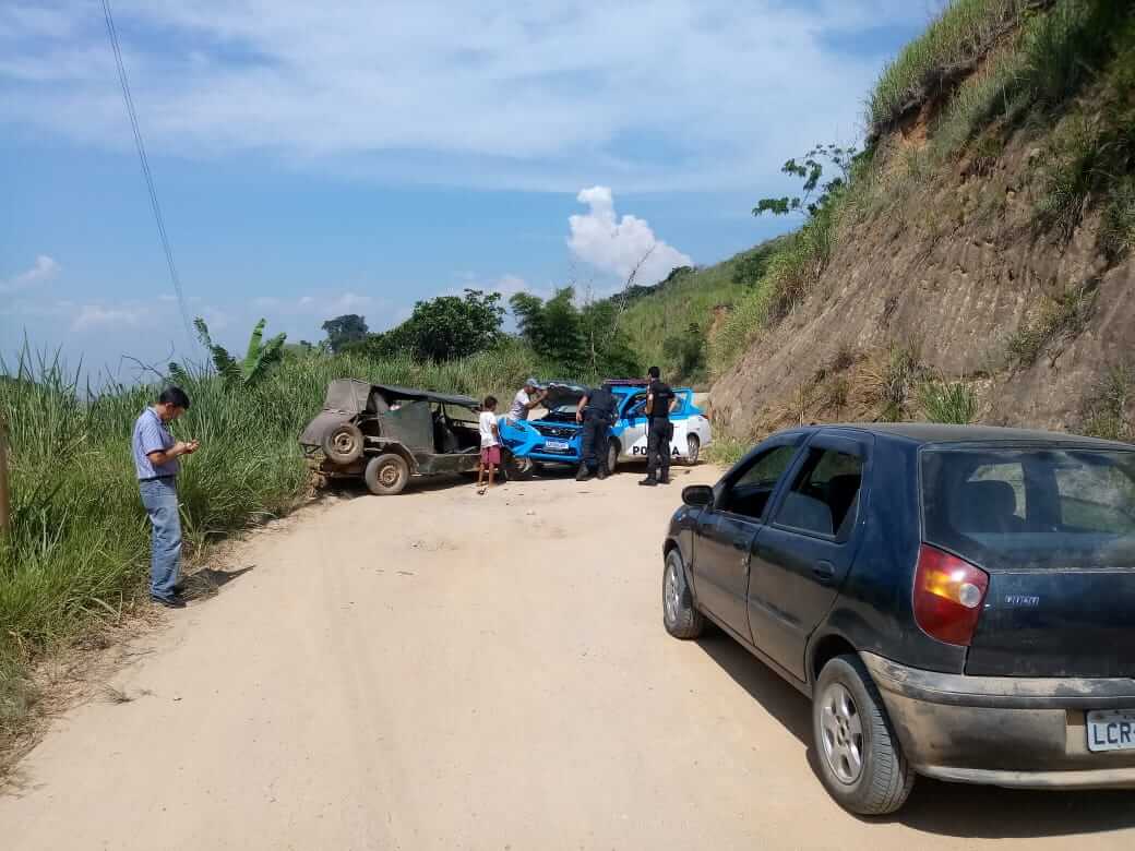 Policiais e o condutor do carro descaracterizado observam o estrago causado com a batida